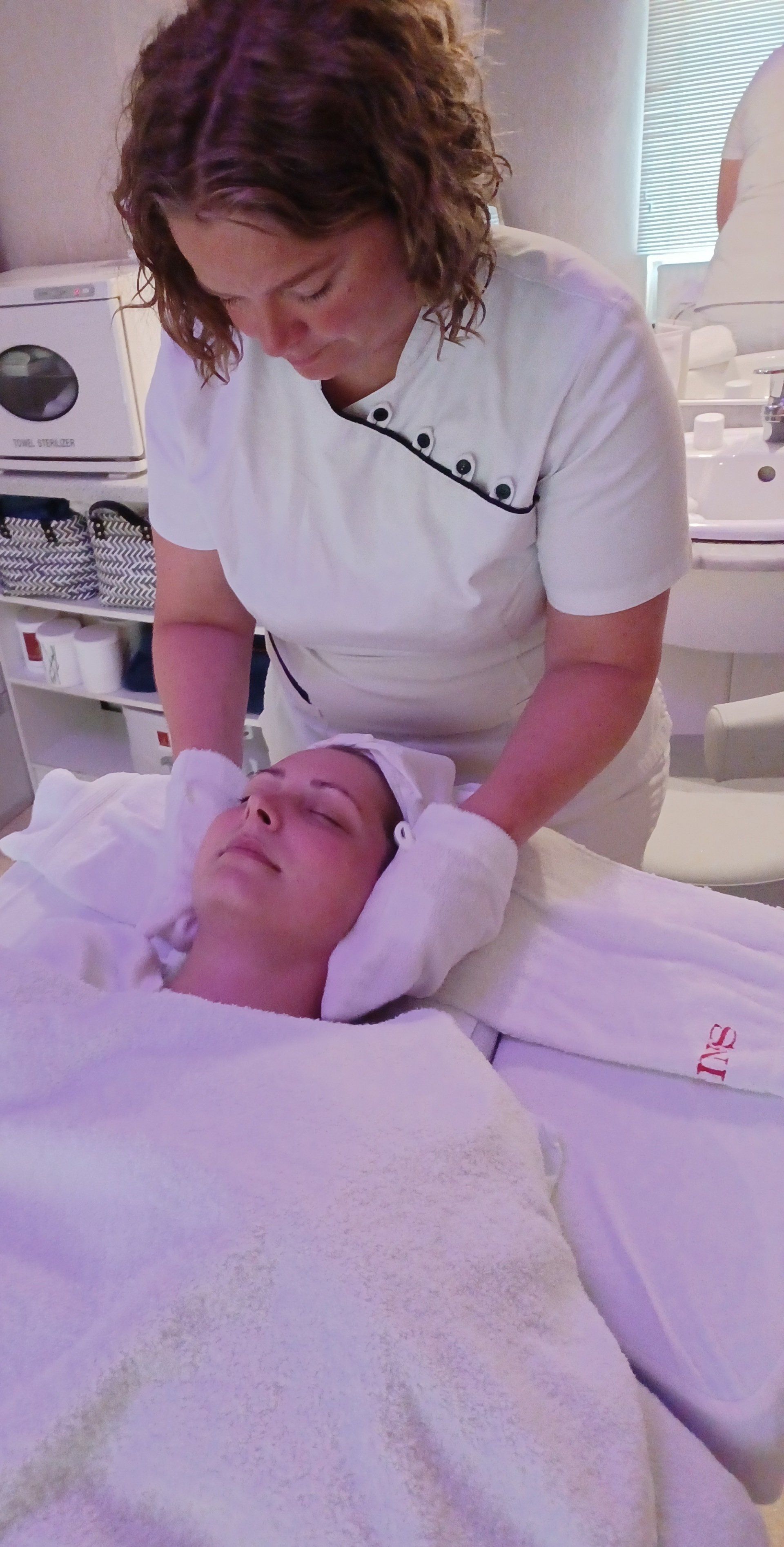 Eine Frau gibt einer anderen Frau in einem Schönheitssalon eine Gesichtsbehandlung.