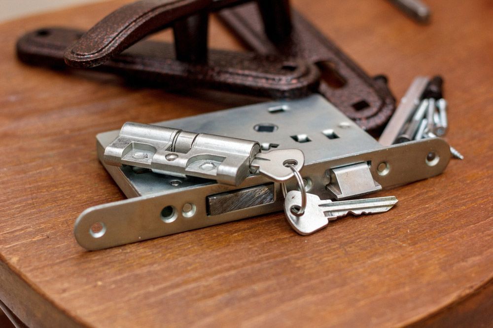 A Close Up Of A Door Lock And Keys On A Wooden Table — SPL Security Solutions In Main Beach, QLD