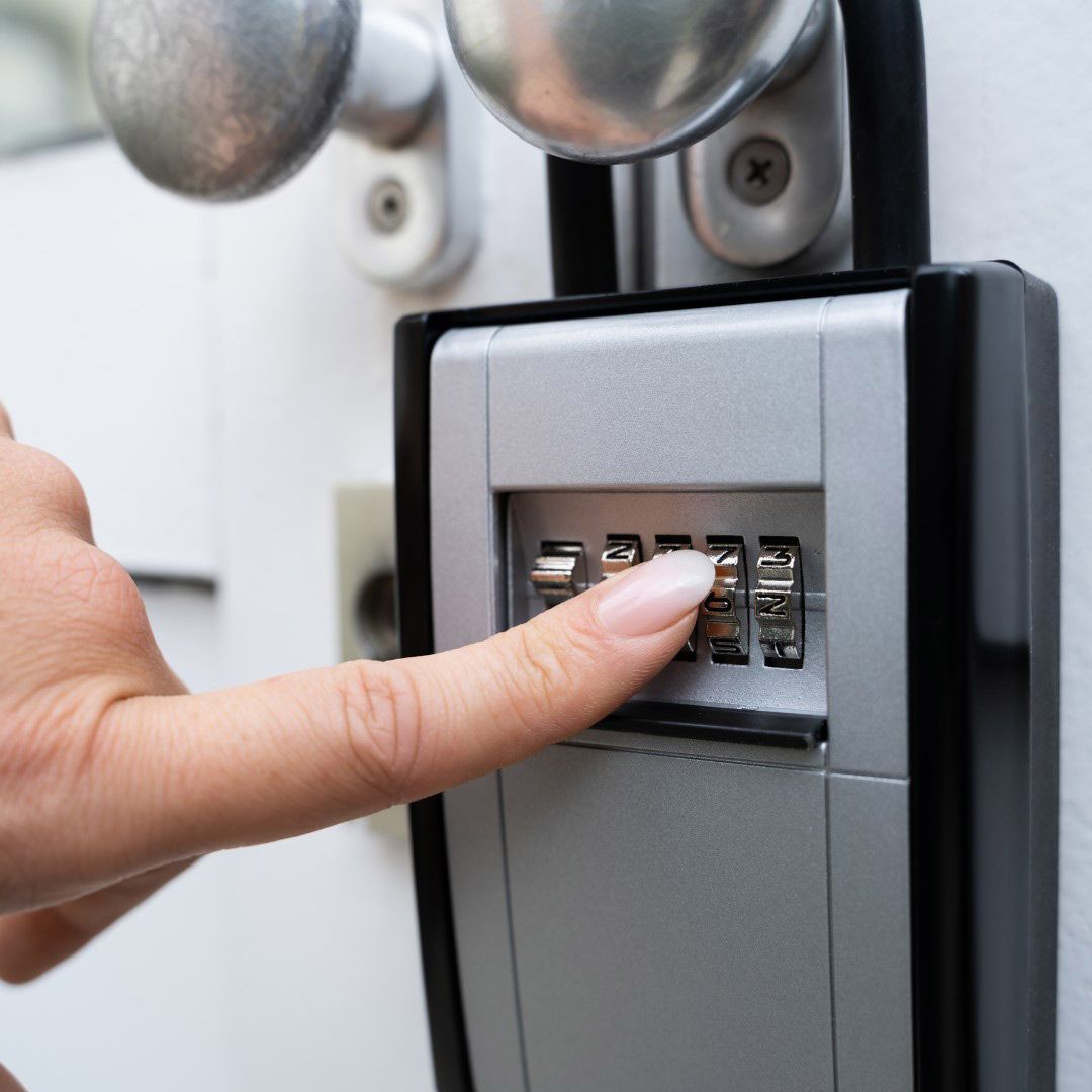 A Person's Finger is Pressing a Button on a Key Safe — SPL Security Solutions In Coomera, QLD