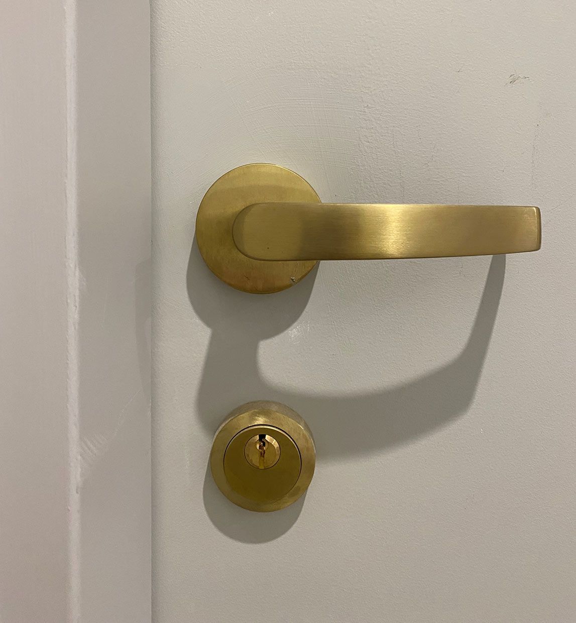 A White Door With a Gold Door Handle and Lock — SPL Security Solutions In Tweed Heads, NSW