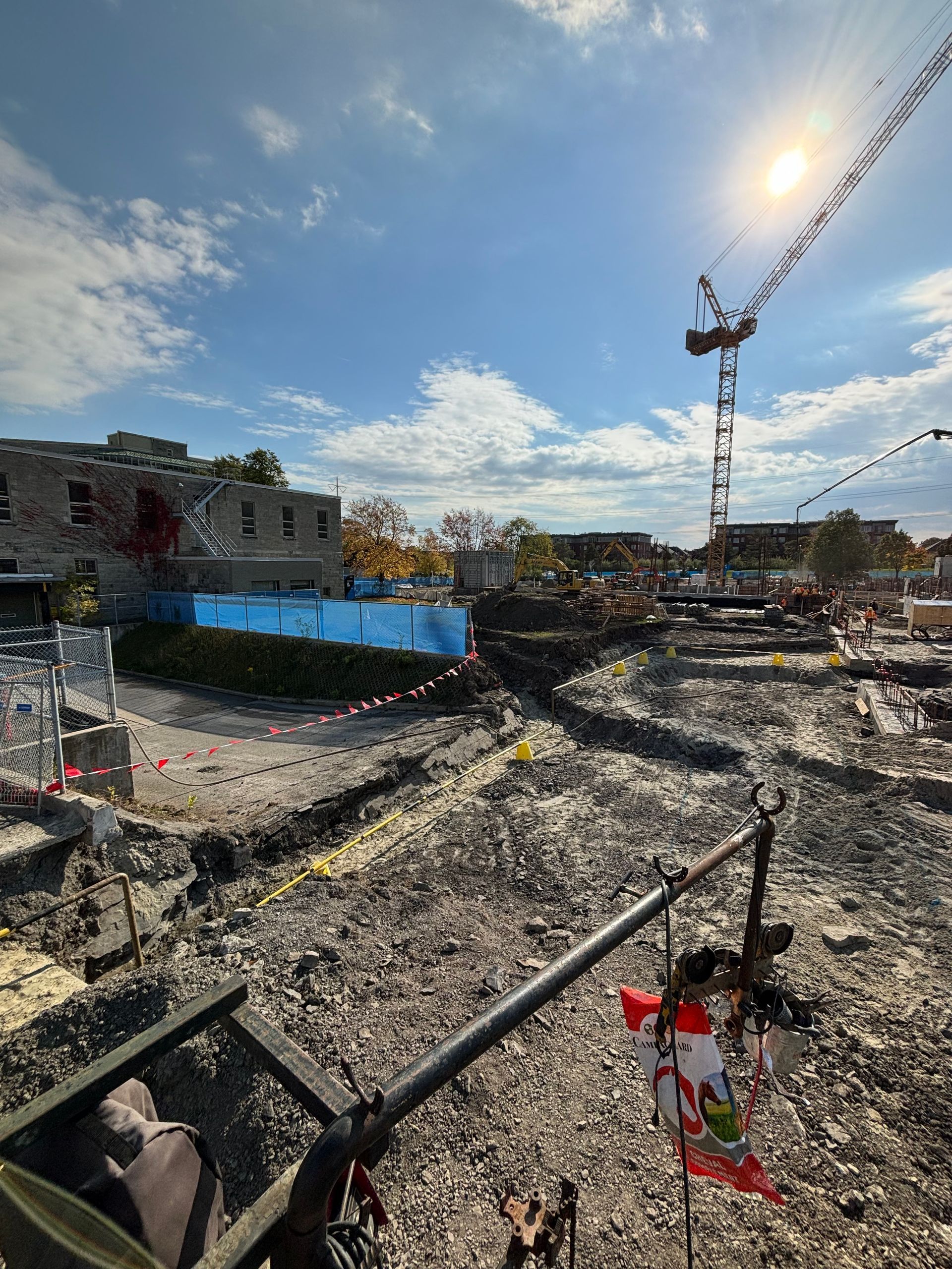 Construction site with a crane under a sunny blue sky.