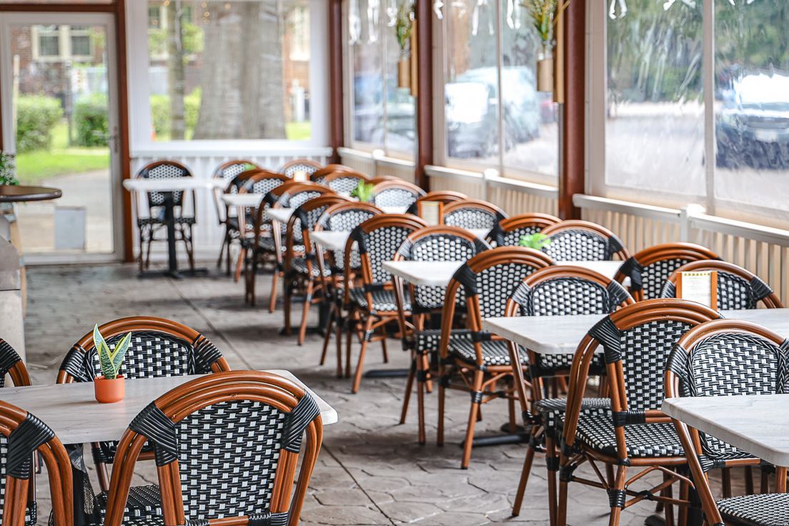 A restaurant with tables and chairs under a canopy.
