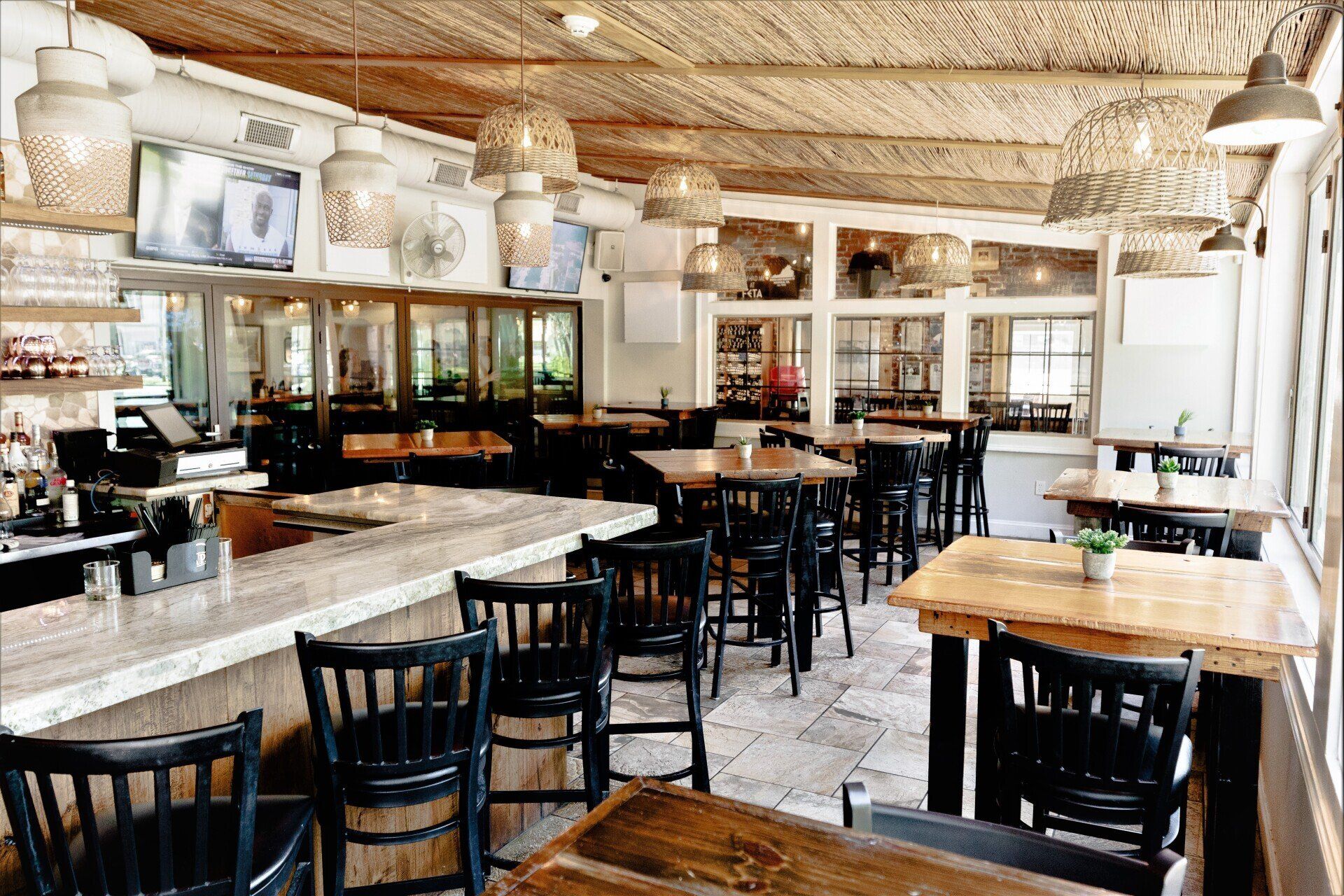 A restaurant with tables and chairs and a bar.