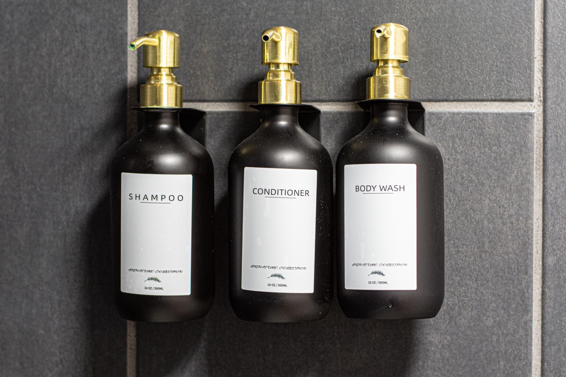 Three black bottles with gold pumps, labeled 