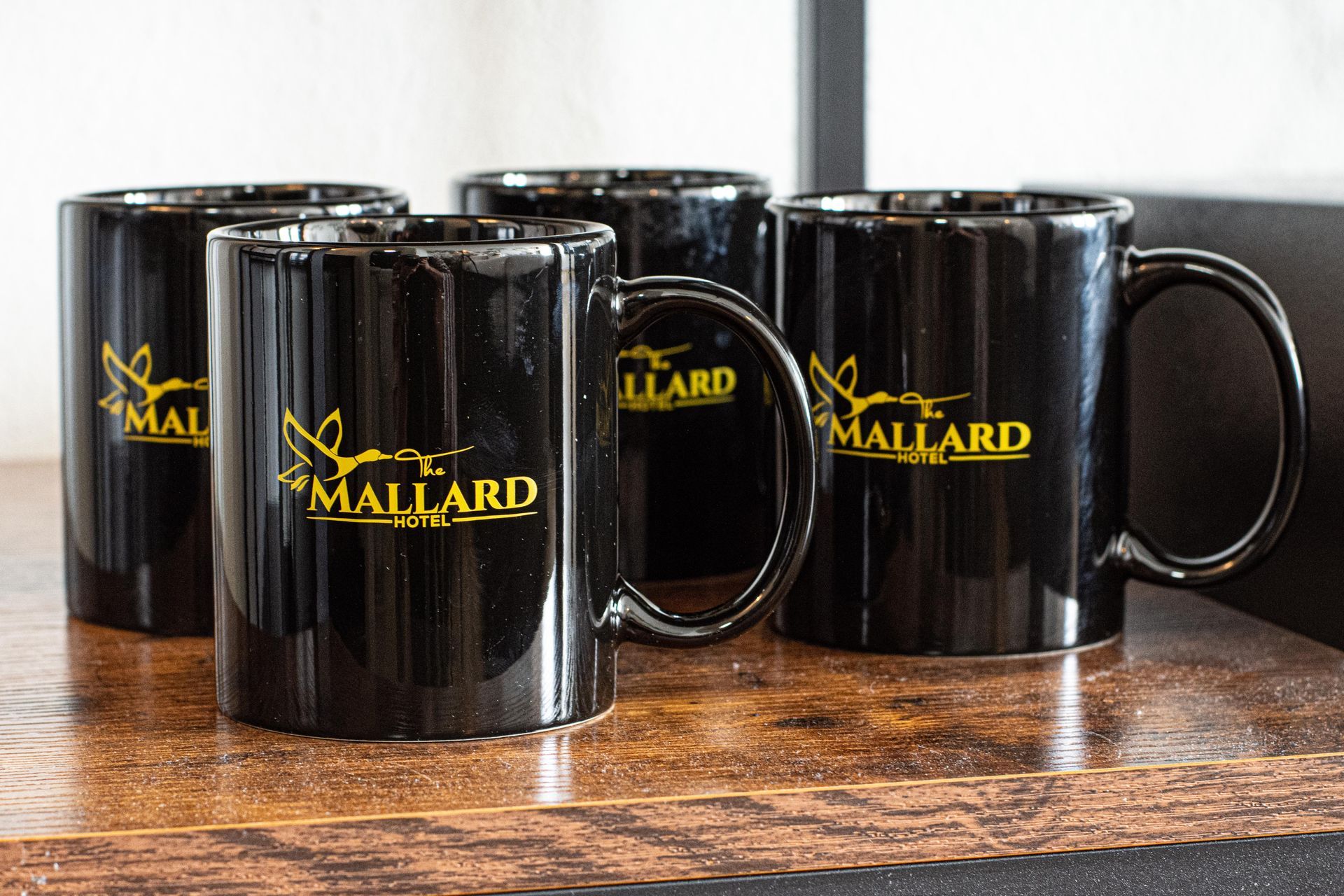 Four black mugs with a gold 