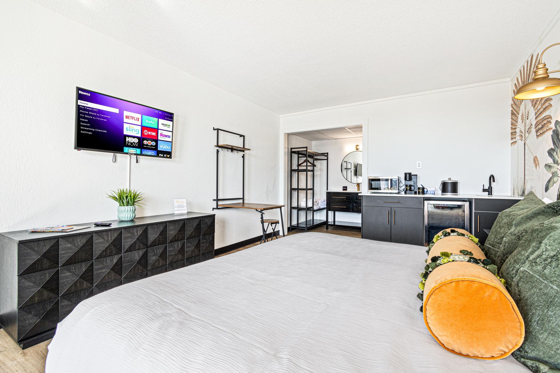 Side view of king sized bed showing flat screen tv, counter and mini fridge
