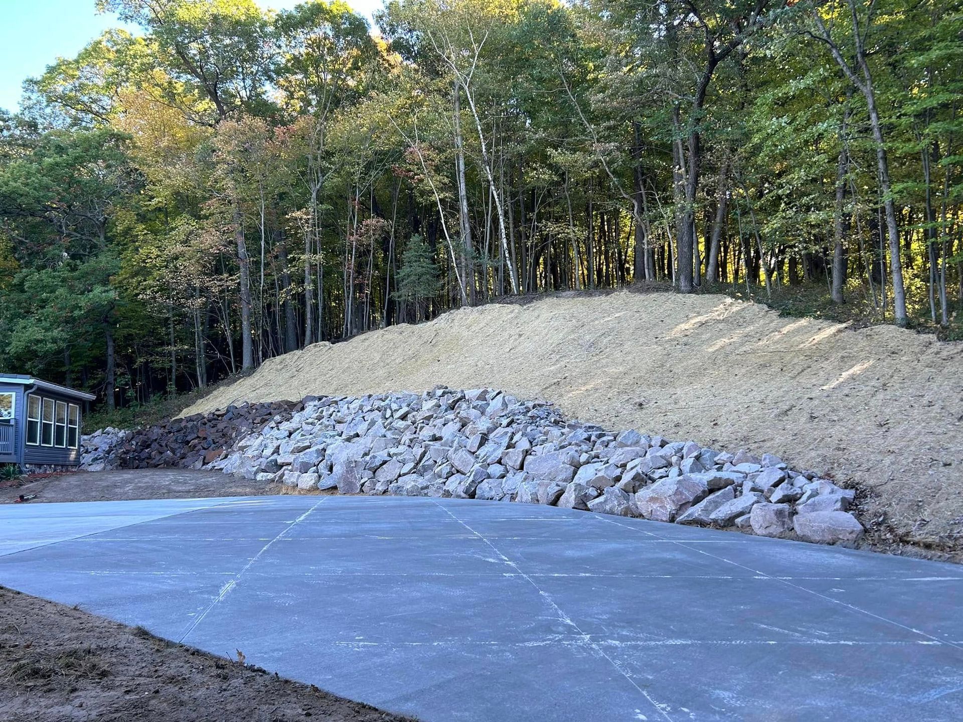 The picture shows a retaining wall on the side a forest in Eau Claire, WI.