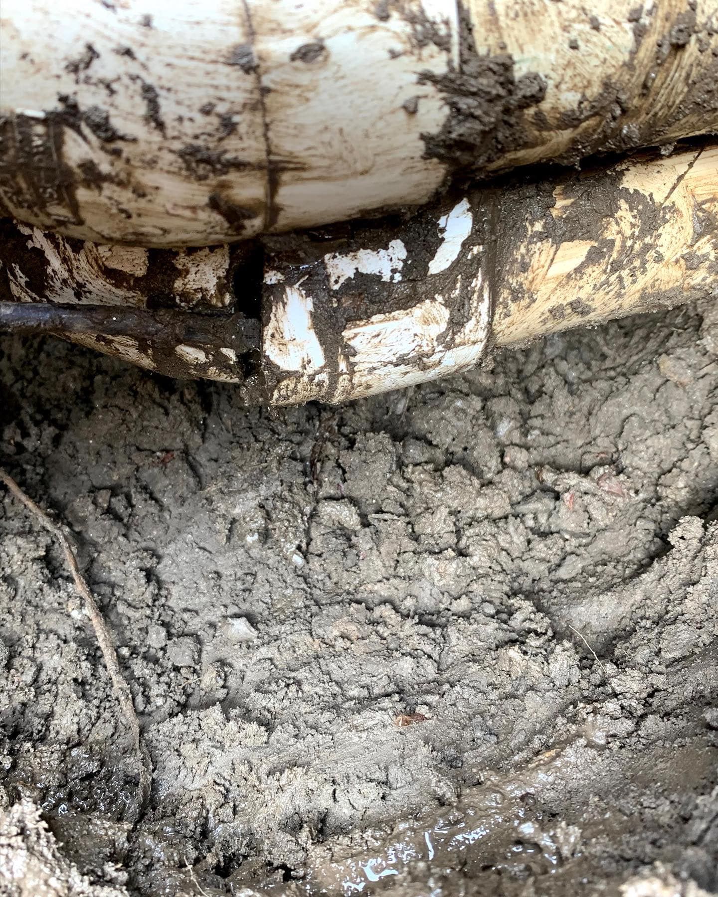 a close up of a muddy surface with a pipe in the background .