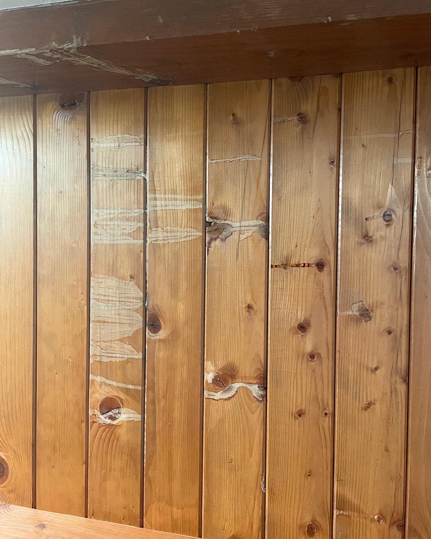 a wooden wall with a few holes in it