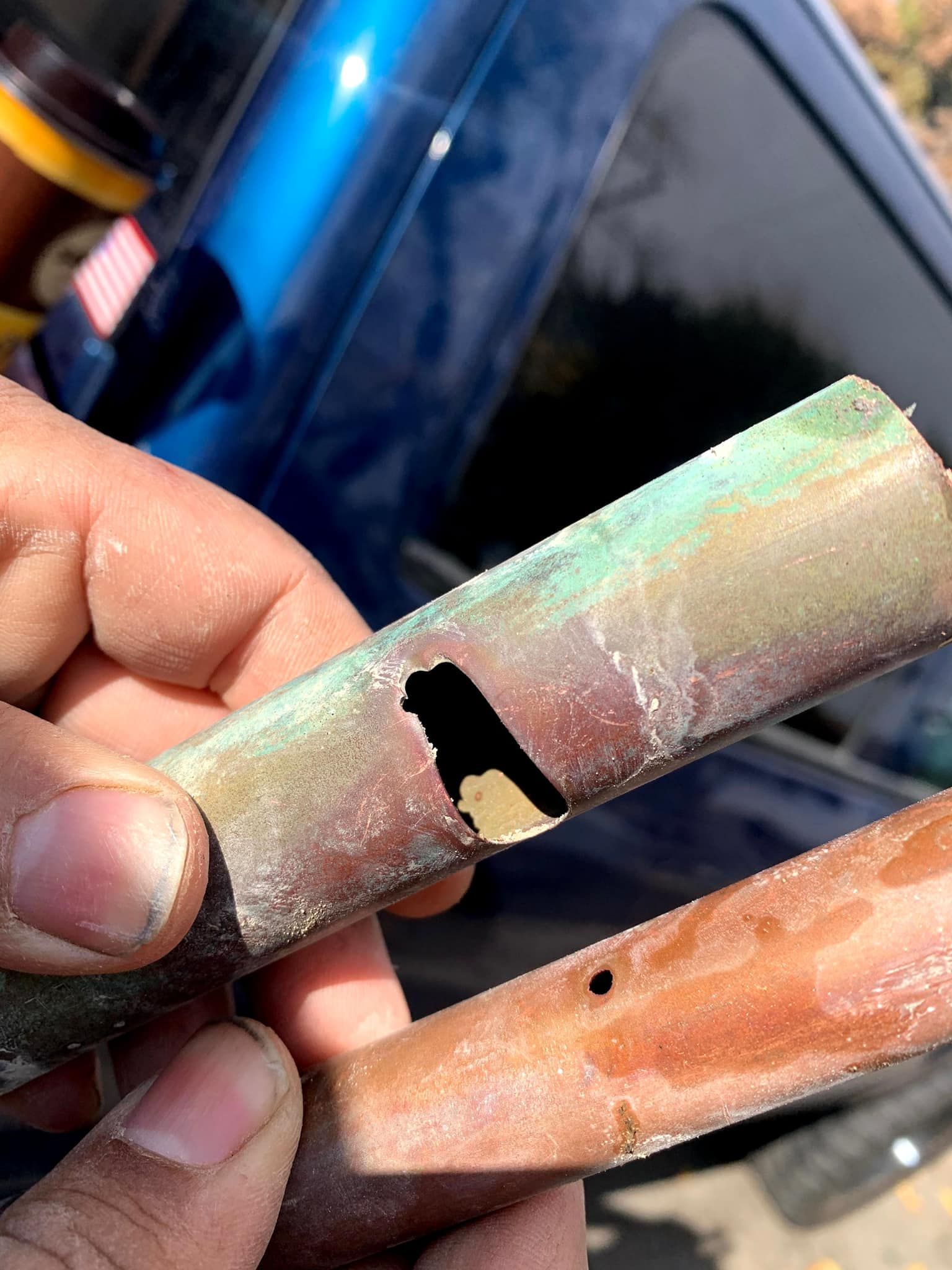 a person is holding a piece of metal with a hole in it .