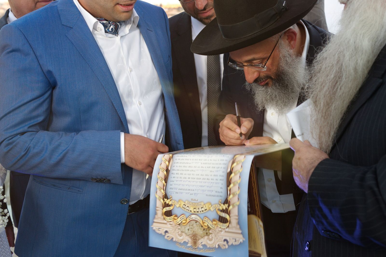 גברים מניחים מגש כסף שעליו פריטי נוי מזהב במהלך חתימה או בדיקה טקסית - צילום חתונות - גיל דור