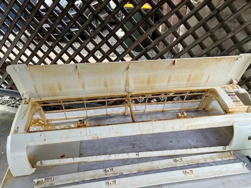 A Dirty White Item Is Sitting In Front Of A Wooden Fence — More Clean Air In Maitland, NSW