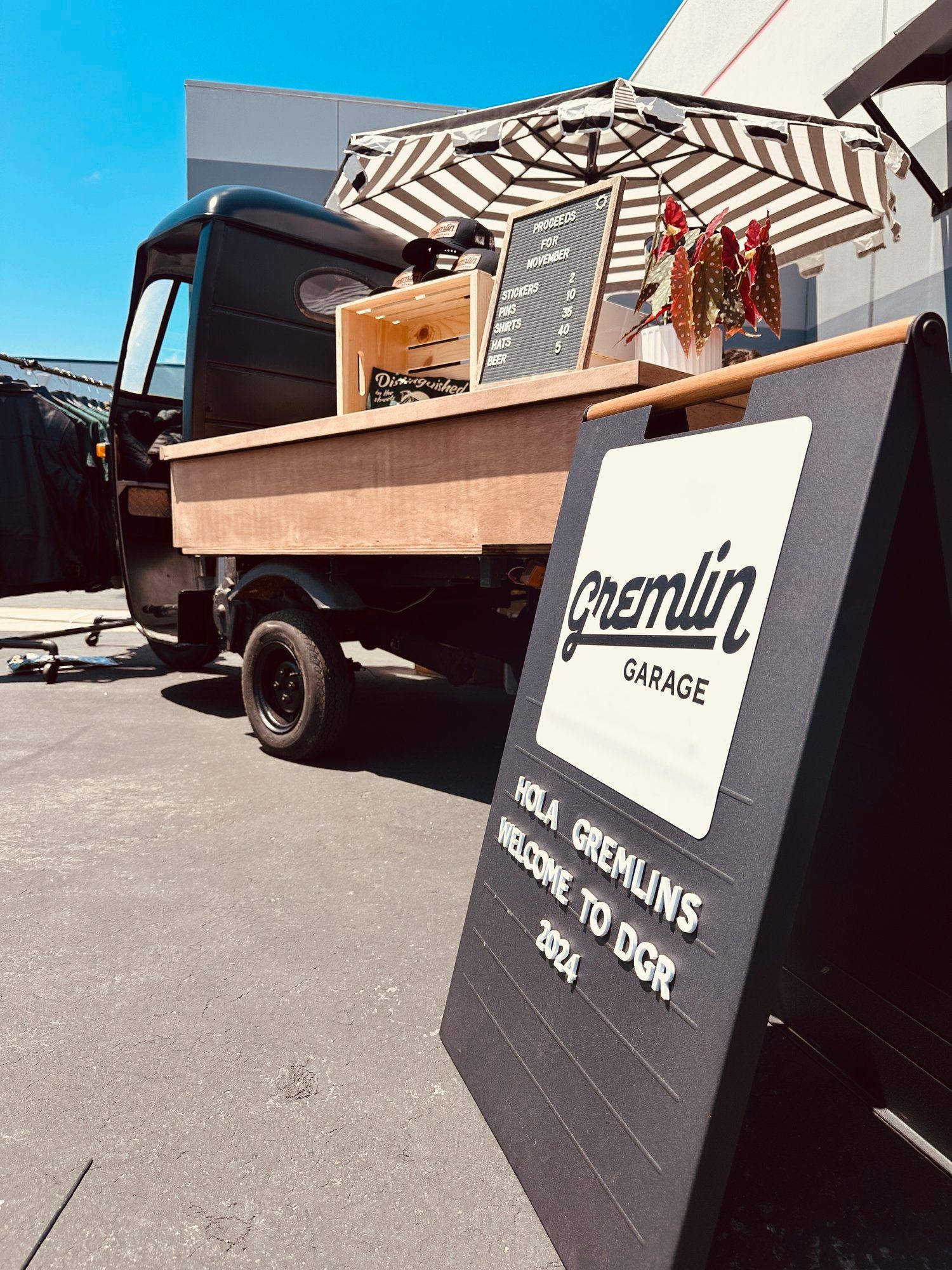 A food truck is parked in a parking lot next to a sign.