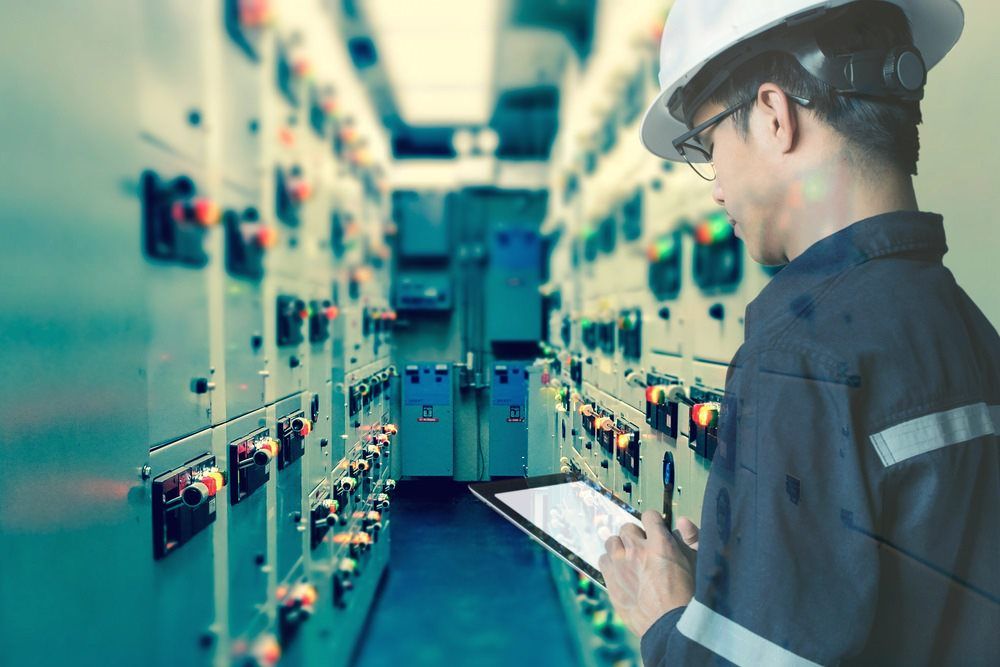 Man Using Tablet To Inspect Power Supply Systems — Barnes Electrical in Gladstone, QLD