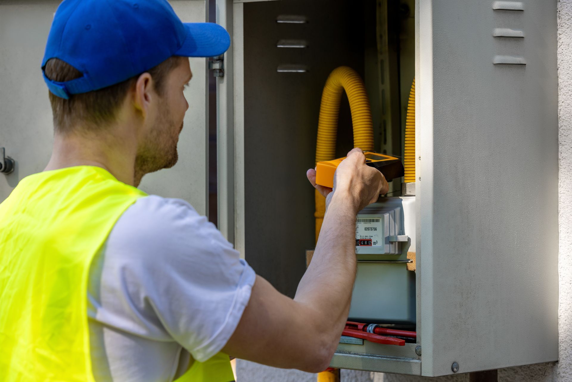 Close-up of a technician using a gas detector device, looking for a gas leak. A technician checking a natural gas leak with a detector in a meter box.