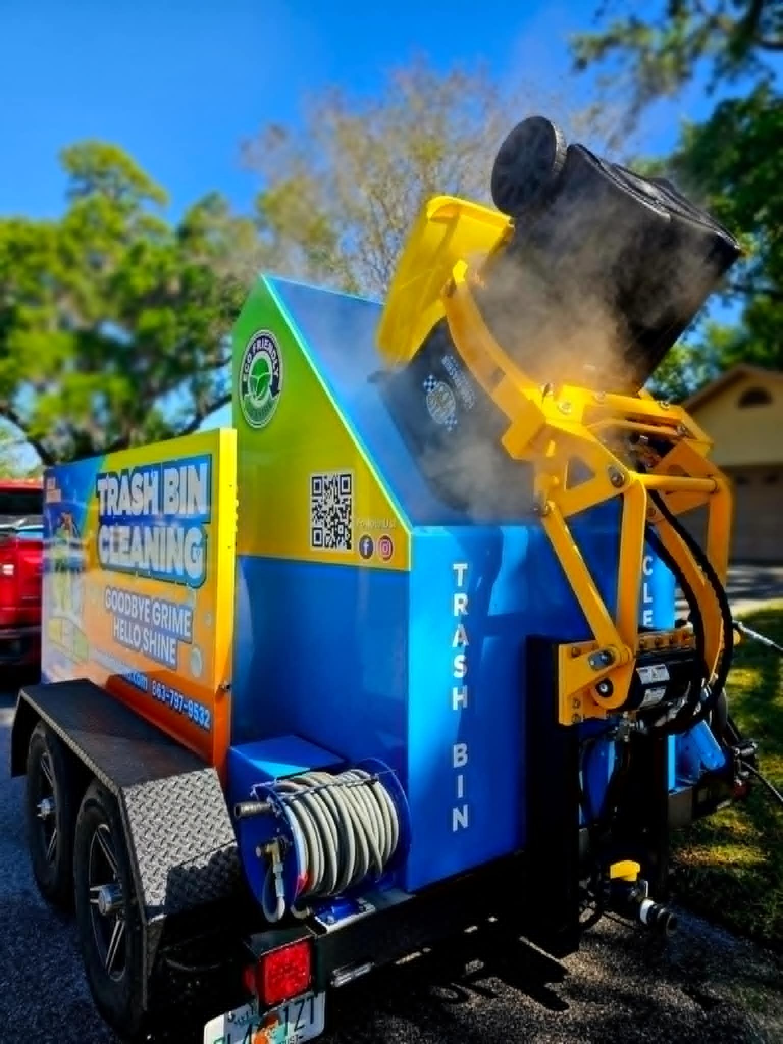 A man is standing in front of a garbage truck