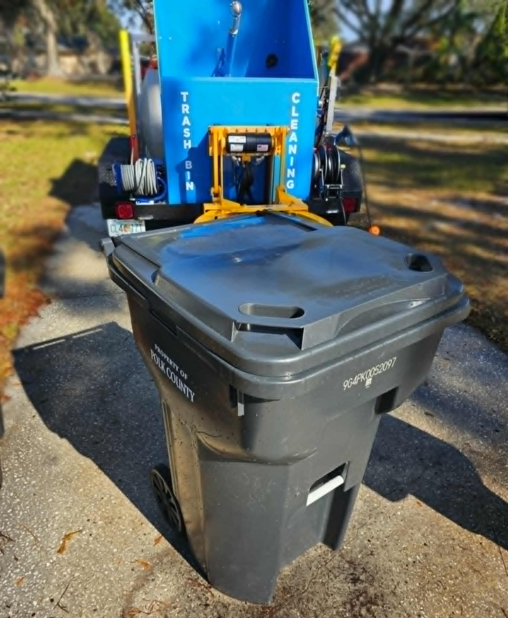 Two blue recycling bins are sitting on the side of the road.