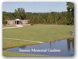 Stinrise Memorial Gardens lawn and pond with a small brick building in the background