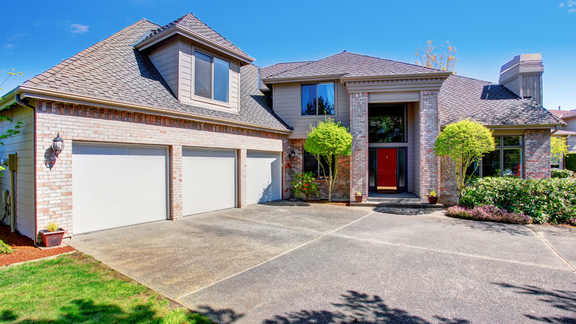 Suburban brick house with two-car garage, front walkway, and landscaped yard