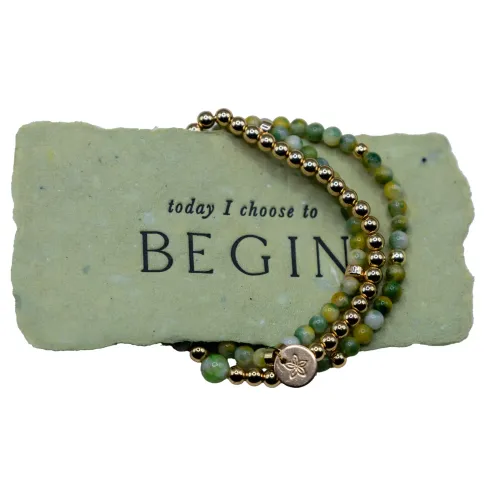 Stone with “today I choose to BEGIN” and a green-beaded bracelet draped across it