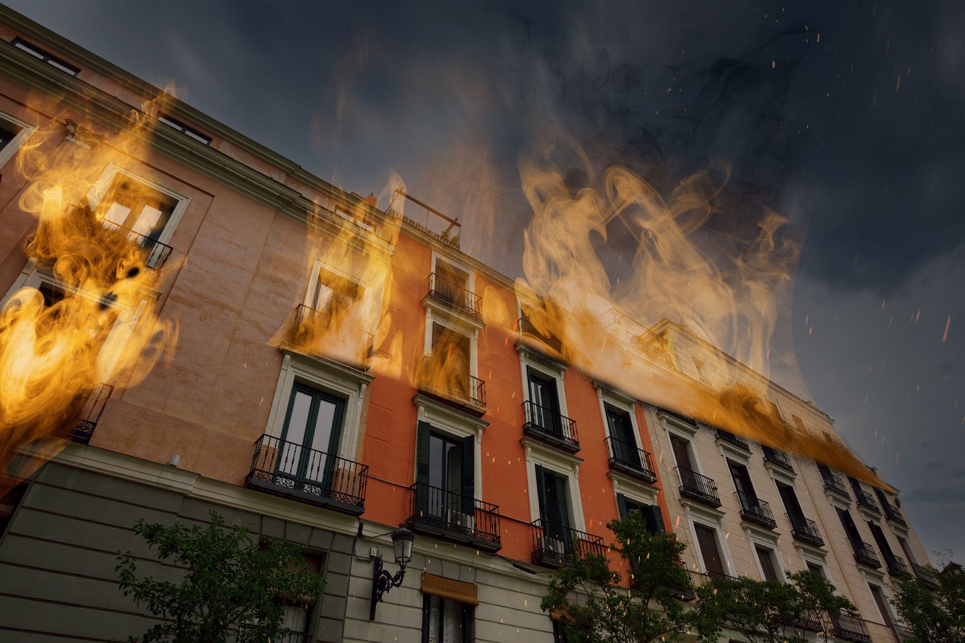 Building engulfed in flames; orange and yellow fire against a cloudy sky.
