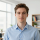Portrait of a man in a light blue shirt standing in a bright office
