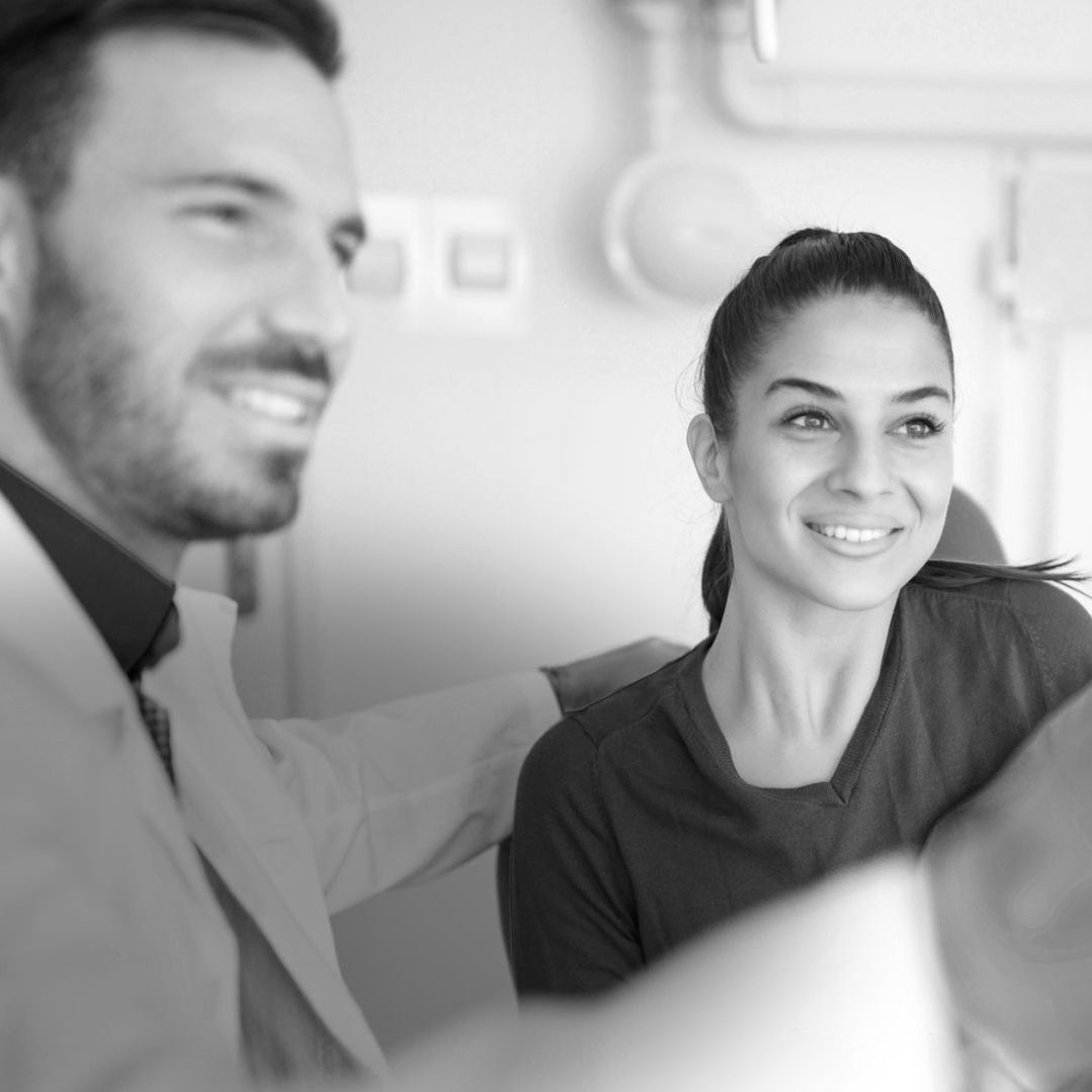 an orthodontist looks at a scan with a female patient