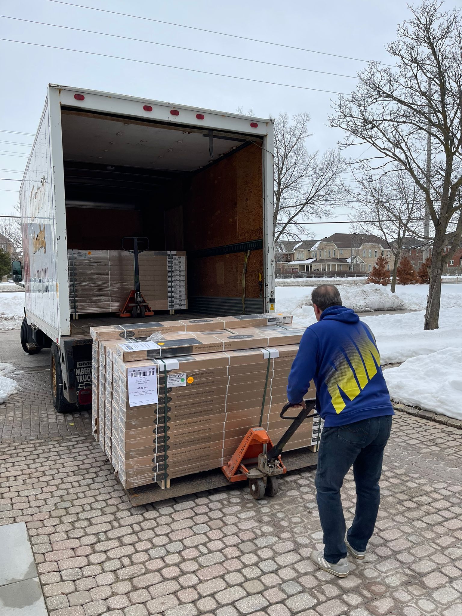 A man is pushing a pallet of boxes into a truck.