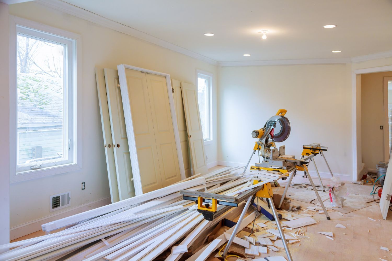 Room undergoing renovation with doors, trim, and saw.