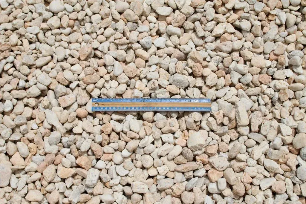 Blue ruler lying on tan gravel stones