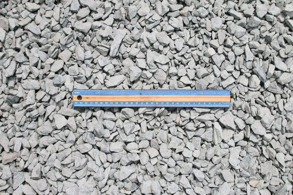 Orange ruler lying on gray gravel stones