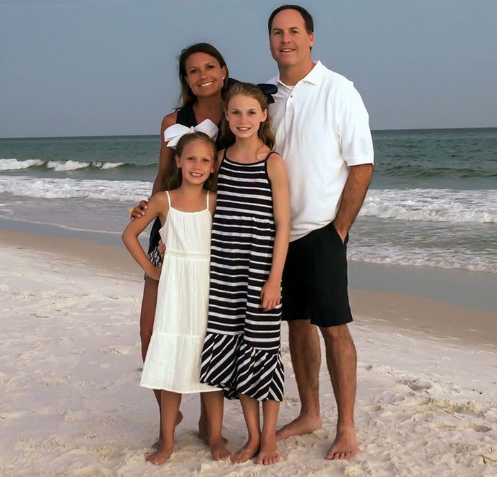 A family poses for a picture on the beach