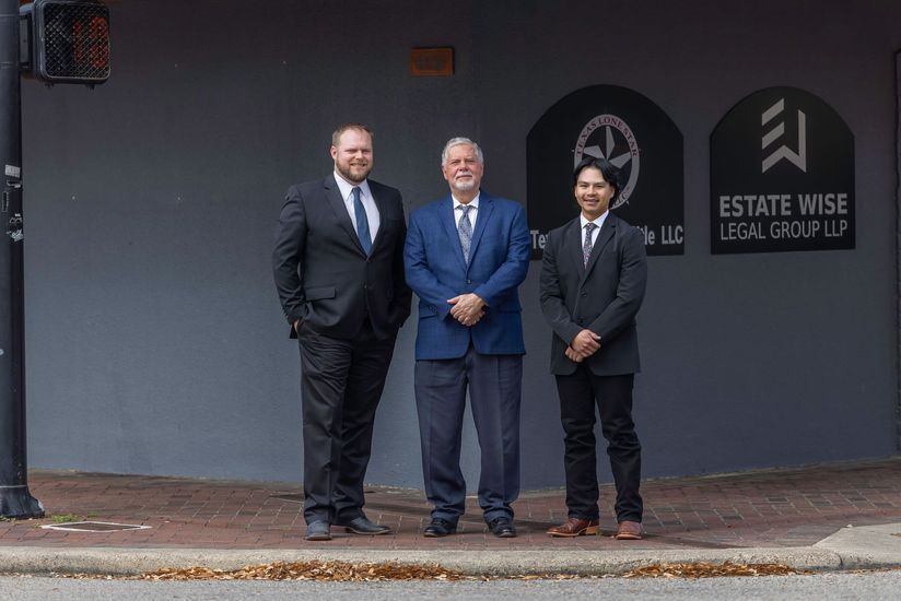 Three men in suits standing outside Estate Wise Lettings & Property on a sidewalk.