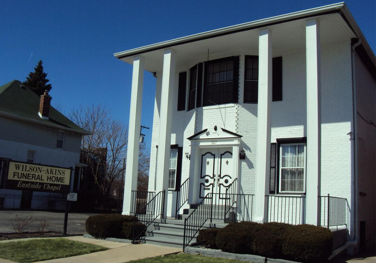 White building with large pillars; sign reads 