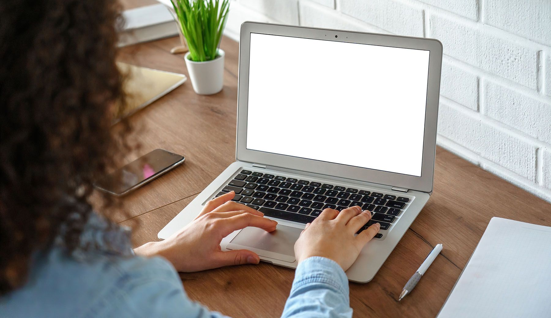 A man and a woman are sitting on a couch looking at a laptop computer.