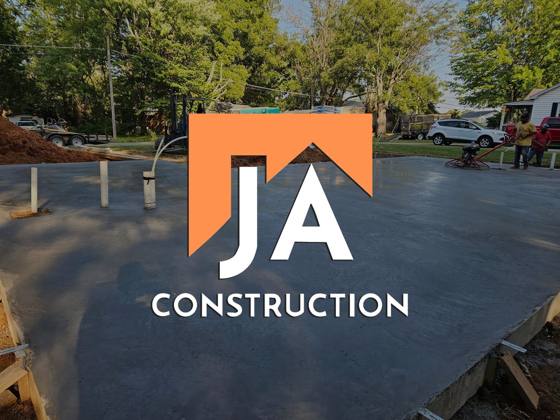 The logo for ja construction is on a concrete driveway