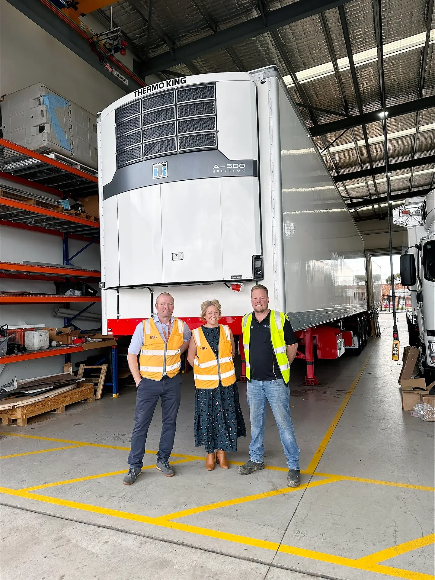 A large white refrigeration trailer is being built with Thermo King
