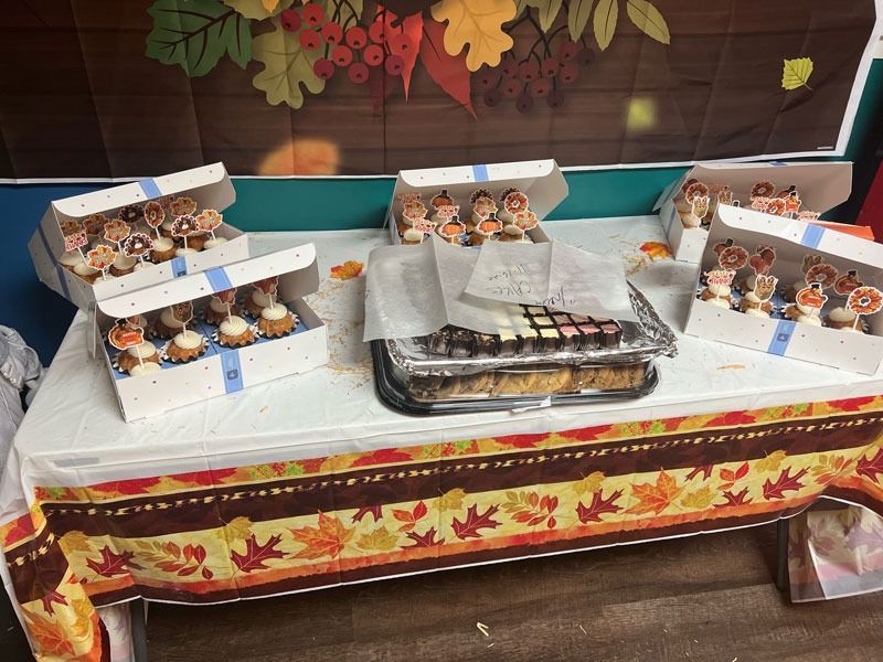 Autumn-themed dessert table with assorted pastries and small treats in white trays