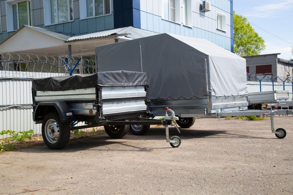 Two Trailers Are Parked In A Parking Lot In Front Of A Building — MTM Automotive in Bentley Park, QLD