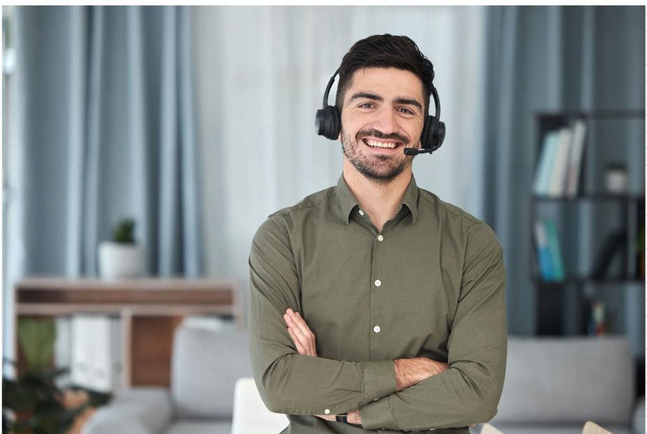 Picture of male smiling with headset on and arms crossed