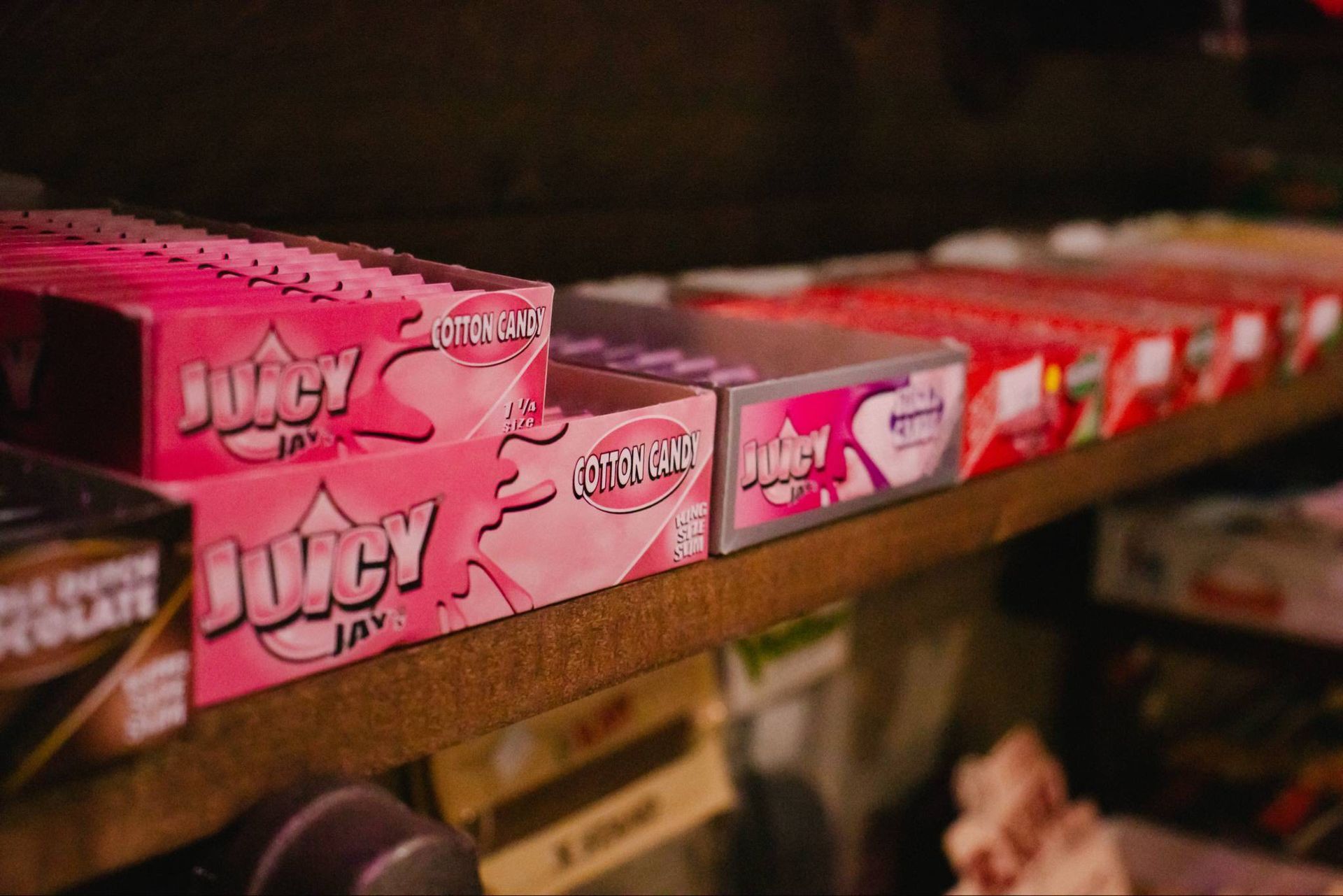 Pink candy boxes lined up on a store shelf, with one box in the foreground.