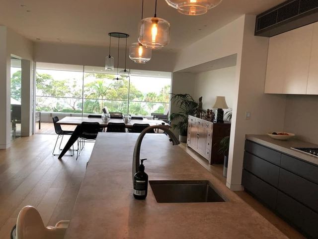 Modern open-concept kitchen and dining area with island, pendant lights, and large window view