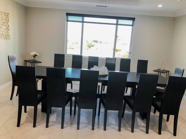 Dining room with a black table and chairs in front of a large window.