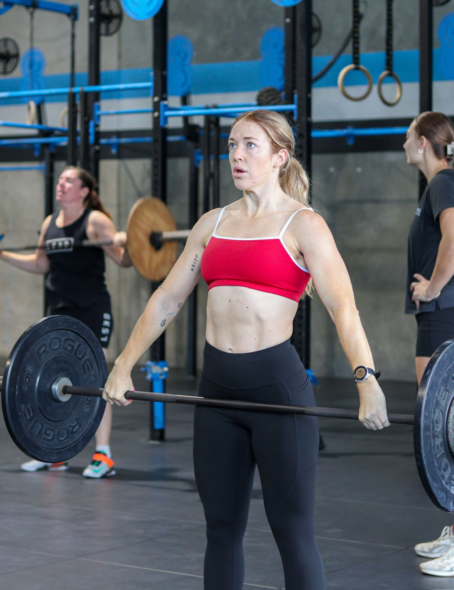 A woman is lifting a barbell in Rebuild Health and Fitness in Wynnum West & Capalaba, QLD