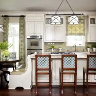 Bright kitchen with white cabinets, wood island stools, and dark hardwood floors