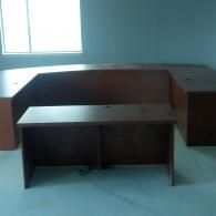 Office desk setup in a sparse room with blue walls and a window