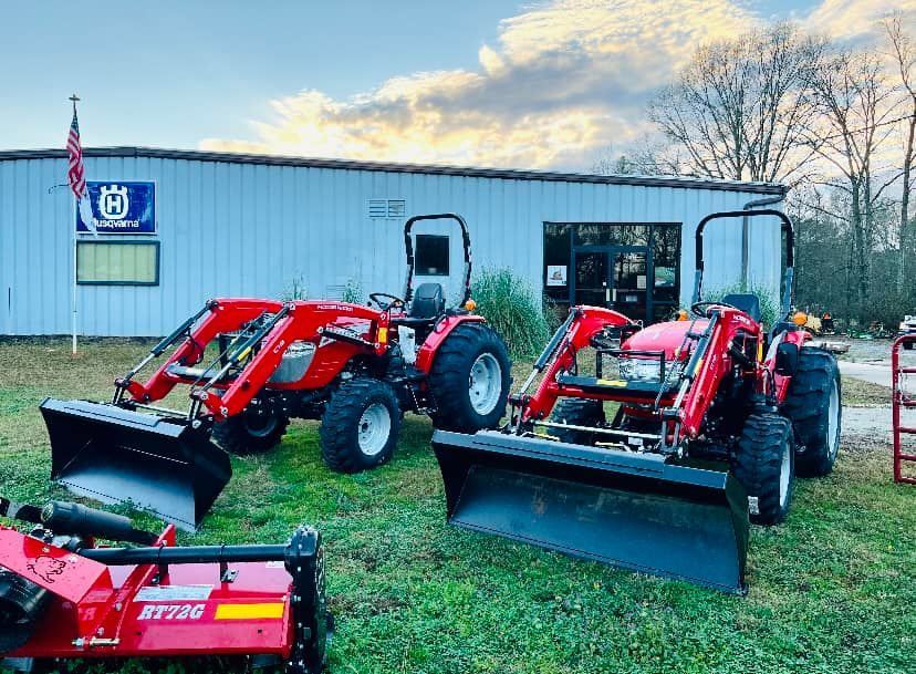A row of tractors are parked in front of a building.