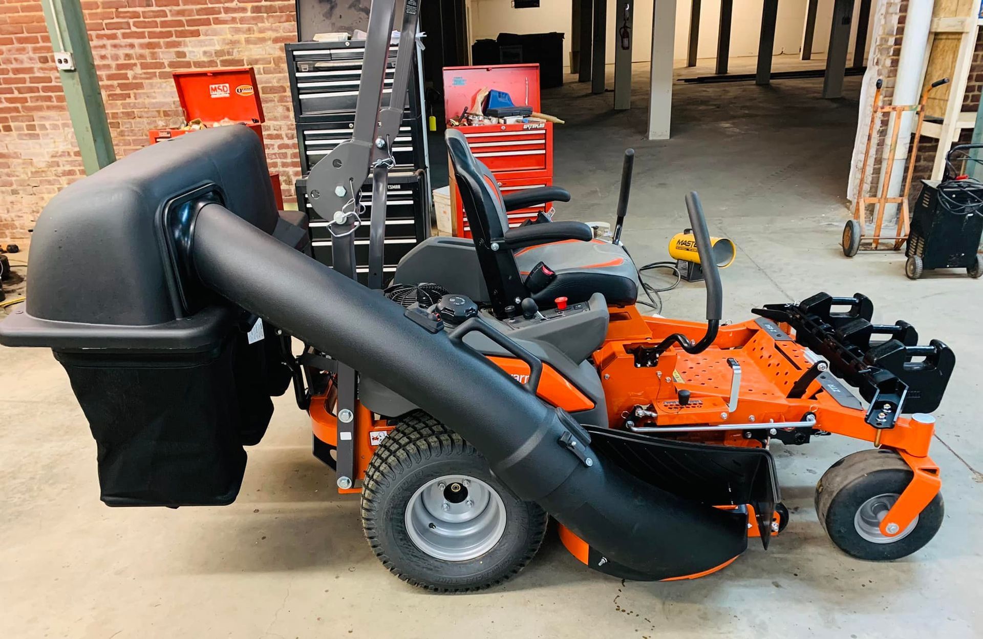 A lawn mower with a vacuum attached to it