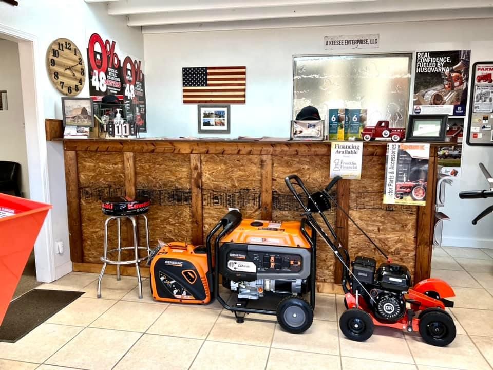 A lawn mower and a generator are sitting in front of a counter in a store.