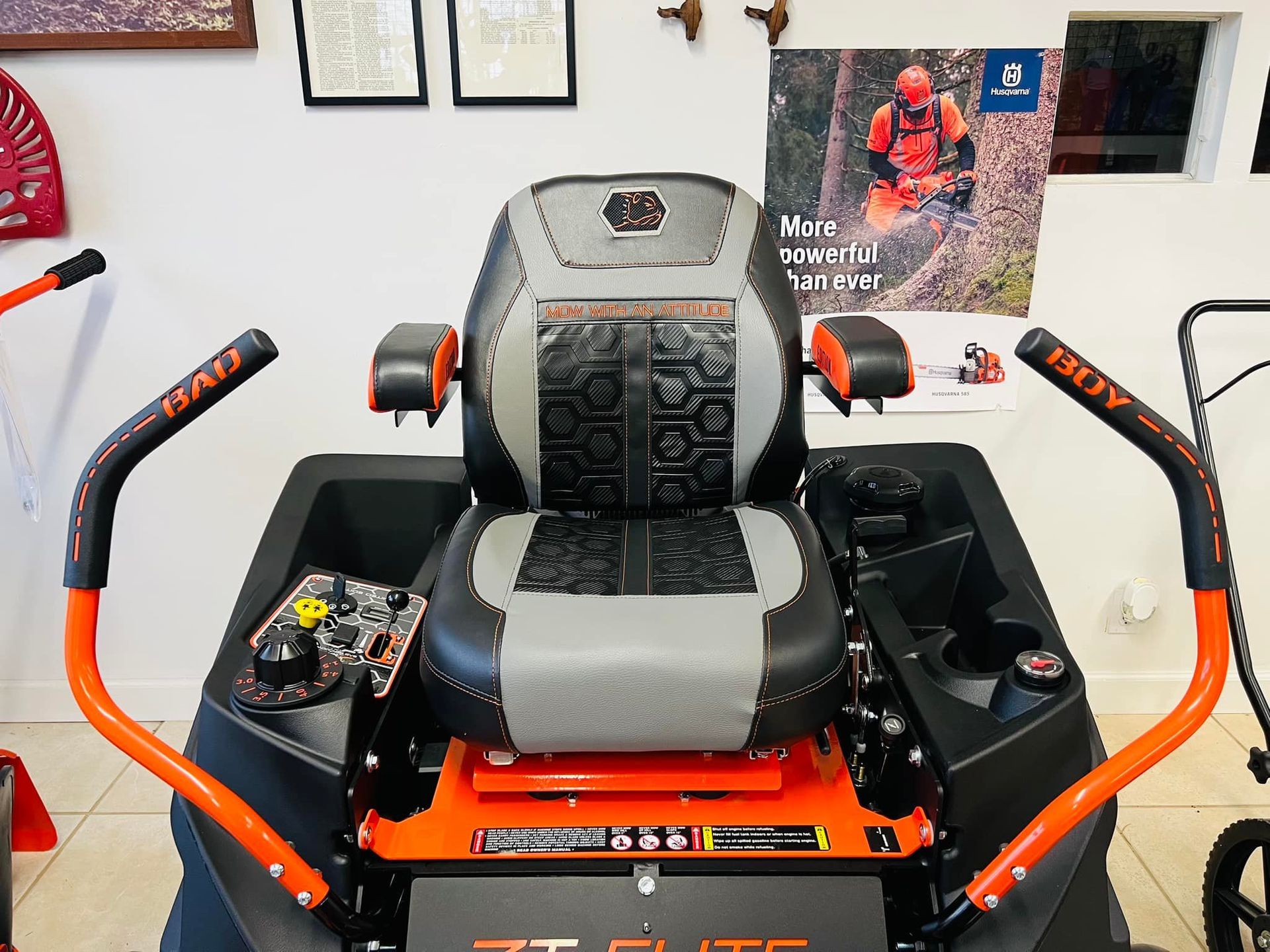 A black and orange lawn mower with a gray seat
